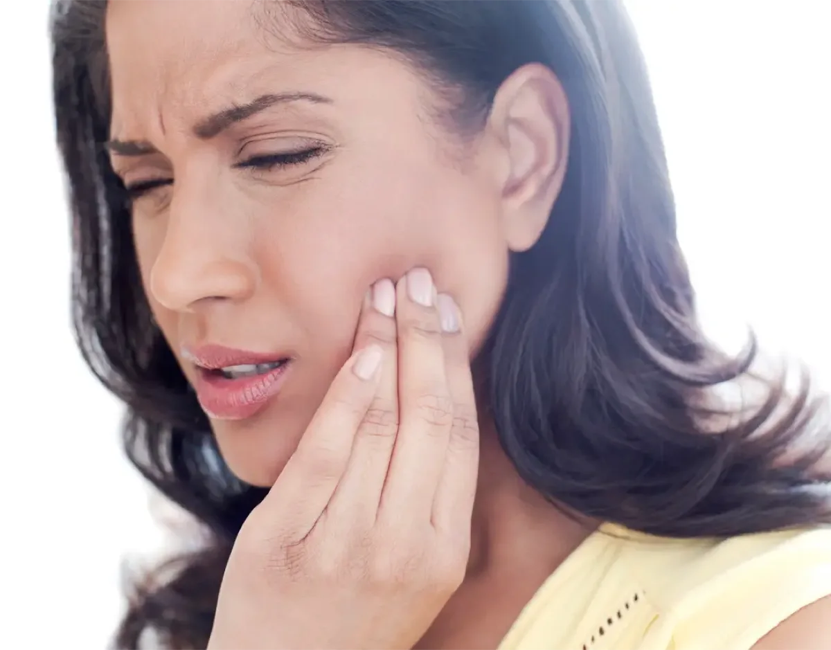 Woman holding her jaw in pain from a severe toothache
